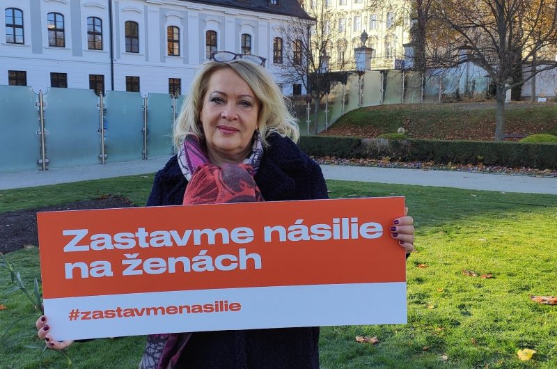 Fotka Silvie Porubänovej v parku s tabuľkou Zastavme násilie na ženách